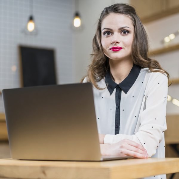 portrait-pretty-woman-sitting-front-laptop-wooden-table